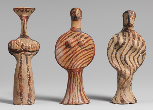 three figurines painted with ochre swirls