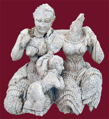 two women carved in ivory, embracing, with child playing at their laps