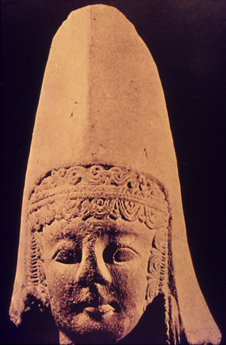 limestone head of woman in high peaked headdress with elaborate headband decoration