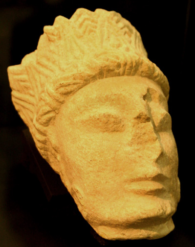 left side view of woman's head with patterned headdress