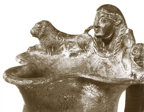 female head flanked by lions at rim of bronze vessel