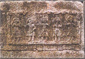 rough stone relief of women with upraised hands