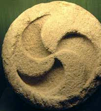 three-legged whorl: stone relief in circular shape