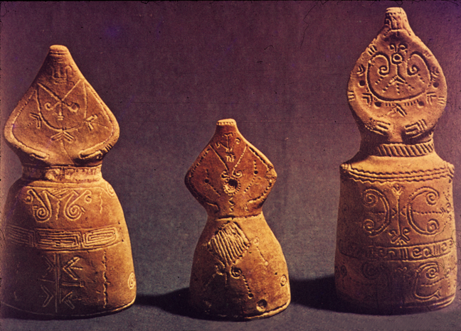 three figurines with long skirts and incised decorations
