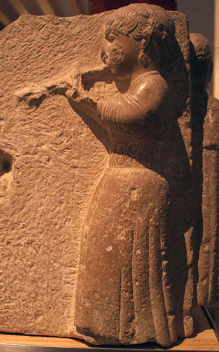 elegant woman with spiralled belt playing double pipes