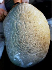 round stone with headdress and necklace, face and arms